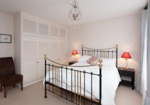 ein Schlafzimmer mit einem Bett, einem Stuhl und einem Kronleuchter in der Unterkunft The Hart Street Residence in Edinburgh