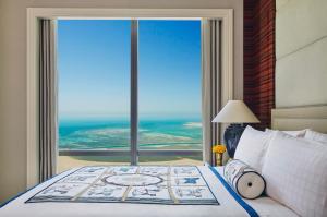 a bedroom with a bed with a large window at Four Seasons Hotel Bahrain Bay in Manama