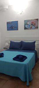 1 dormitorio con 1 cama azul y 2 cuadros en la pared en APARTAMENTO ALEGRANZA, en Orzola