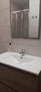 lavabo blanco en el baño con espejo en APARTAMENTO ALEGRANZA, en Orzola