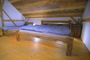 a bed in a room with a wooden ceiling at Horská chalupa Jeřabina in Horní Blatná
