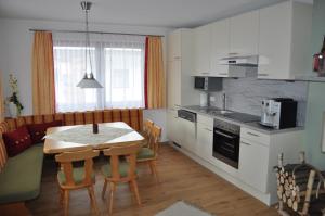 Haus Christl في أشاو: مطبخ وغرفة طعام مع طاولة وكراسي