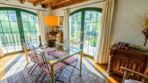 a dining room with a table and chairs and windows at Villa Hidalgo Arenas by Ruralidays in Arenas