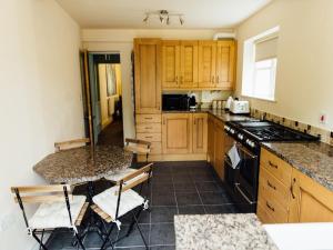 a kitchen with wooden cabinets and a table with chairs at Langs Hall in Leyland