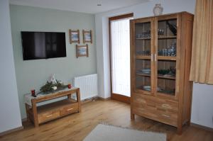 sala de estar con TV y armario de madera en Haus Christl, en Aschau