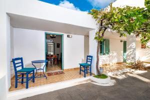 費拉的住宿－Authentic Santorinian Home Experience，庭院配有蓝色的椅子和桌子