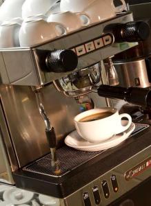 Eine Tasse Kaffee steht auf einer Kaffeemaschine. in der Unterkunft Buchholz Downtown Hotel in Köln