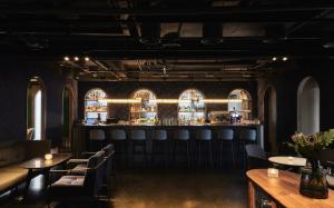 台北Kimpton Da An Taipei- an IHG Hotel的带酒吧的餐厅，酒吧里有椅子和桌子