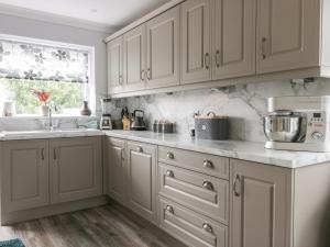 eine Küche mit weißen Schränken und einer Spüle in der Unterkunft Gabby's Garden Cottage in Hull