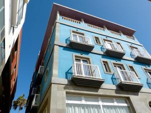 um edifício azul com janelas brancas e varandas em Hotel Tamasite em Puerto del Rosario