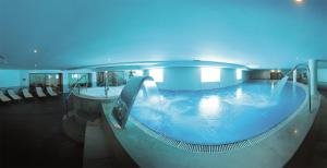 
a large swimming pool in a large building at Vila Gale Ampalius in Vilamoura
