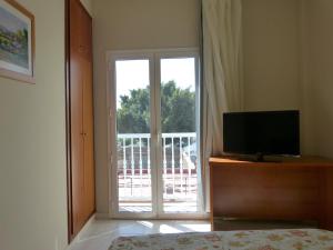 a bedroom with a television and a sliding glass door at Hotel Tamasite in Puerto del Rosario