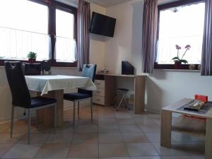 a living room with a table and chairs and windows at Ferienwohnung Ellen in Ehrenberg