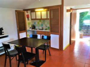 a kitchen with a table and chairs in a room at Casa dos Pintos, Golf e Natureza in Belas