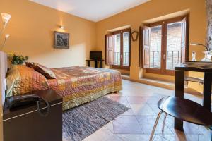 Hotel Cal Llop في غراتالوبس: غرفة نوم بسرير ومكتب ونوافذ