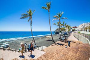 dos personas bajando las escaleras en la playa en Orion, en Puerto Naos