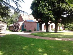 un bâtiment en briques rouges avec un arbre dans la cour dans l'établissement Villa Vigor, à Peer