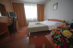 a hotel room with a bed and a table with flowers at Hotel Srbija in Belgrade