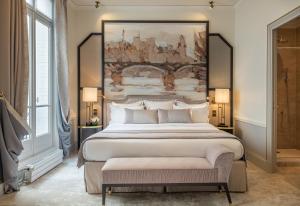 a bedroom with a large bed with a large painting on the wall at Hôtel Elysia by Inwood Hotels in Paris