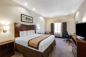 ビクトリアにあるBaymont by Wyndham Victoriaの大きなベッドと机があるホテルの部屋