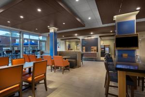 a dining room with tables and chairs and a cafeteria at Holiday Inn Express & Suites - Fayetteville South by IHG in Fayetteville
