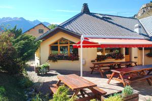 a patio with picnic tables and an umbrella at L'Albaron in Modane