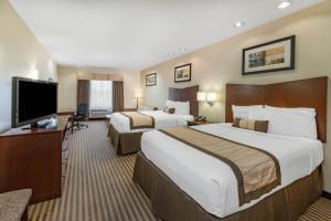 A bed or beds in a room at Baymont by Wyndham Victoria