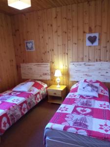 ein Schlafzimmer mit 2 Betten und einem Tisch mit einer Lampe in der Unterkunft Chalet Plein Sud in Montgenèvre