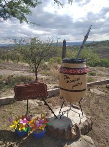 a mortar and pestle with a sign and flowers at Cabañas Dulce Atardecer in Villa Carlos Paz