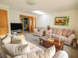 sala de estar con 2 sofás y TV en Avalon, en Cardigan