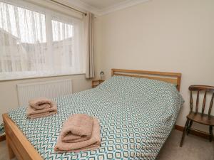 1 dormitorio con 1 cama con toallas en Avalon, en Cardigan