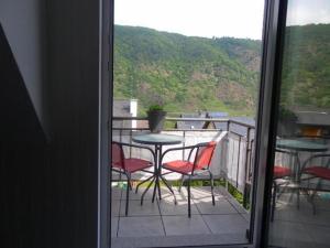 科赫姆的住宿－Haus Avallon，阳台配有桌椅,享有风景。