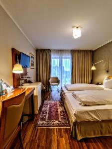 Habitación de hotel con 2 camas y escritorio en Hotel Restaurant Felix en Bensheim