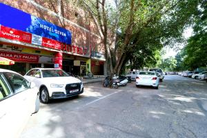 eine Straße mit Autos, die vor einem Gebäude geparkt sind in der Unterkunft Hotel Seven in Chandīgarh
