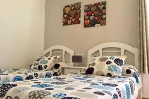 1 dormitorio con 2 camas y almohadas azules y blancas en Rio Sol - Oasis de Privacidad, en Costa Calma