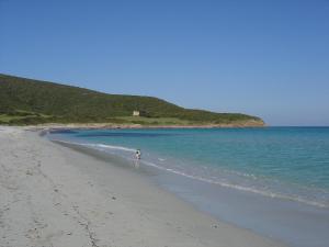 eine Person, die am Strand in der Nähe des Wassers läuft in der Unterkunft Stella Marina in Macinaggio