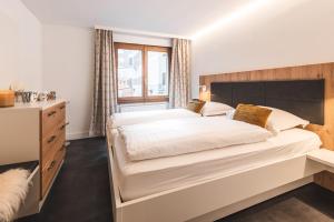 a bedroom with a large bed and a window at Central & Elegant Apartments,partially with Fireplace, by Zermatt Rental in Zermatt