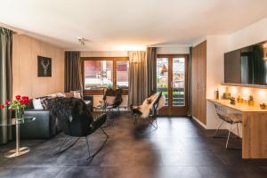 un salon avec un canapé et des chaises dans l'établissement Central & Elegant Apartments,partially with Fireplace, by Zermatt Rental, à Zermatt