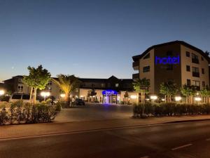 a hotel building with a parking lot at night at Steinberger Hof in Dietzenbach