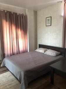 a bedroom with a large bed with pink curtains at Apelsin apartment in Bila Tserkva