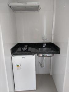 a small kitchen with a sink and a small refrigerator at Residencial Dona Duda in Bombinhas +42 photos