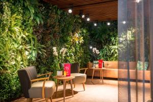 een kamer met een groene muur met stoelen en tafels bij Adagio Amsterdam City South in Amstelveen