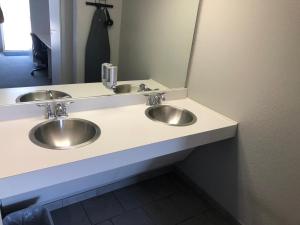 two silver sinks in a bathroom with a mirror at BestWay Inn Oklahoma City Airport in Oklahoma City