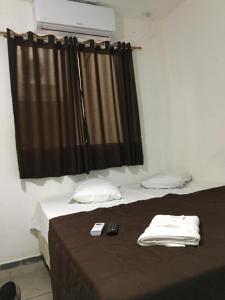 a bedroom with a bed with a black curtain at Hotel Santos Reis in Aparecida