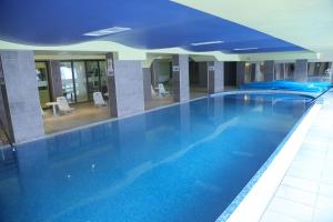 a large blue swimming pool in a hotel room at Mountain Paradise by the Walnut Trees - Free wellness in Bansko