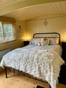 a bed with a white furry comforter in a room at Fourwinds B&B in March