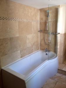 a white bath tub in a bathroom with a shower at The Anchor Inn in Whittonstall