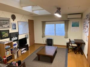 Guesthouse TOMAYA في نيمورو: غرفة معيشة مع طاولة وطاولة قهوة