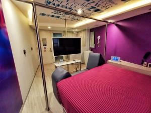 Habitación con cama grande de color rojo y TV. en Hotel Bonn en Ciudad de México