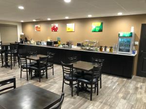 a restaurant with tables and chairs and a bar at Quality Inn & Suites in Paragould